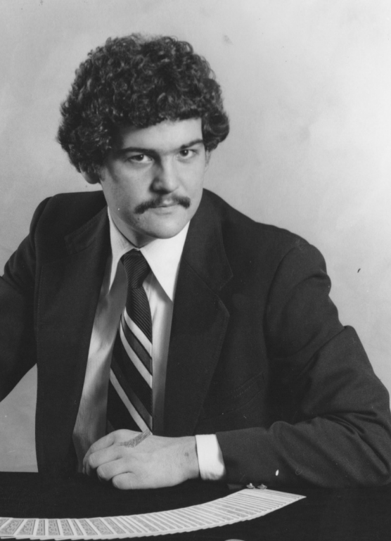 A man in a suit and tie is sitting at a table