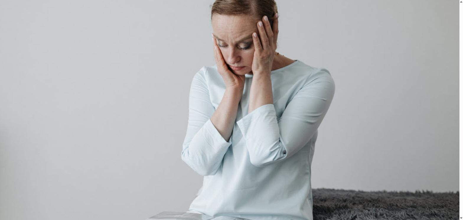 Worried woman resting her head in her hands while sitting