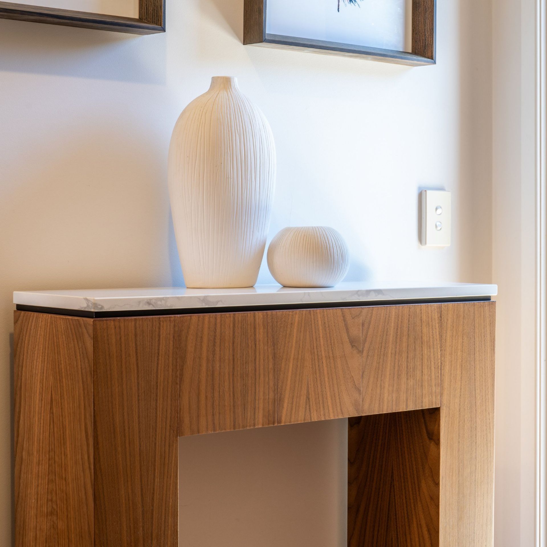 A wooden table with two vases on top of it