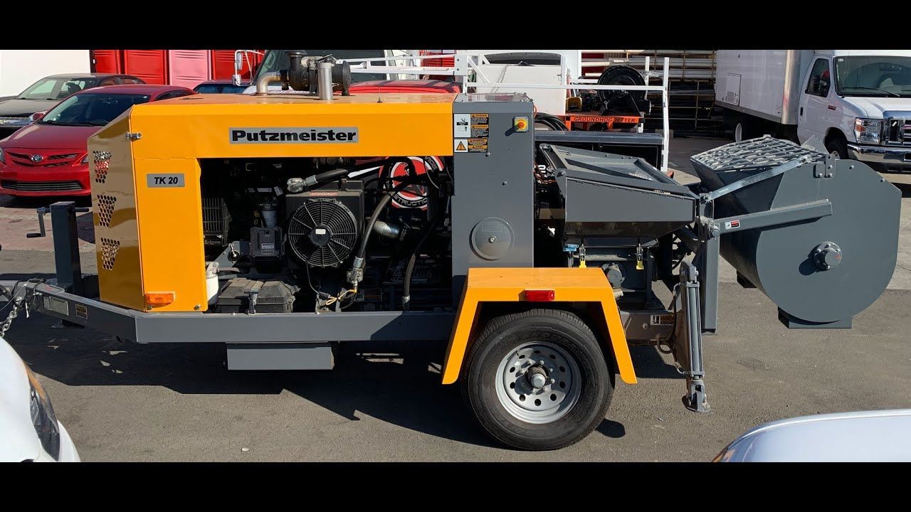 A yellow and gray trailer-mounted industrial pump machine parked in a paved outdoor lot.