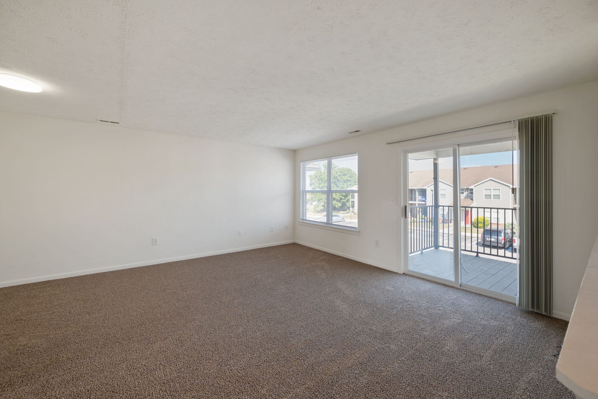 Living room with view of balcony and sliding doors.