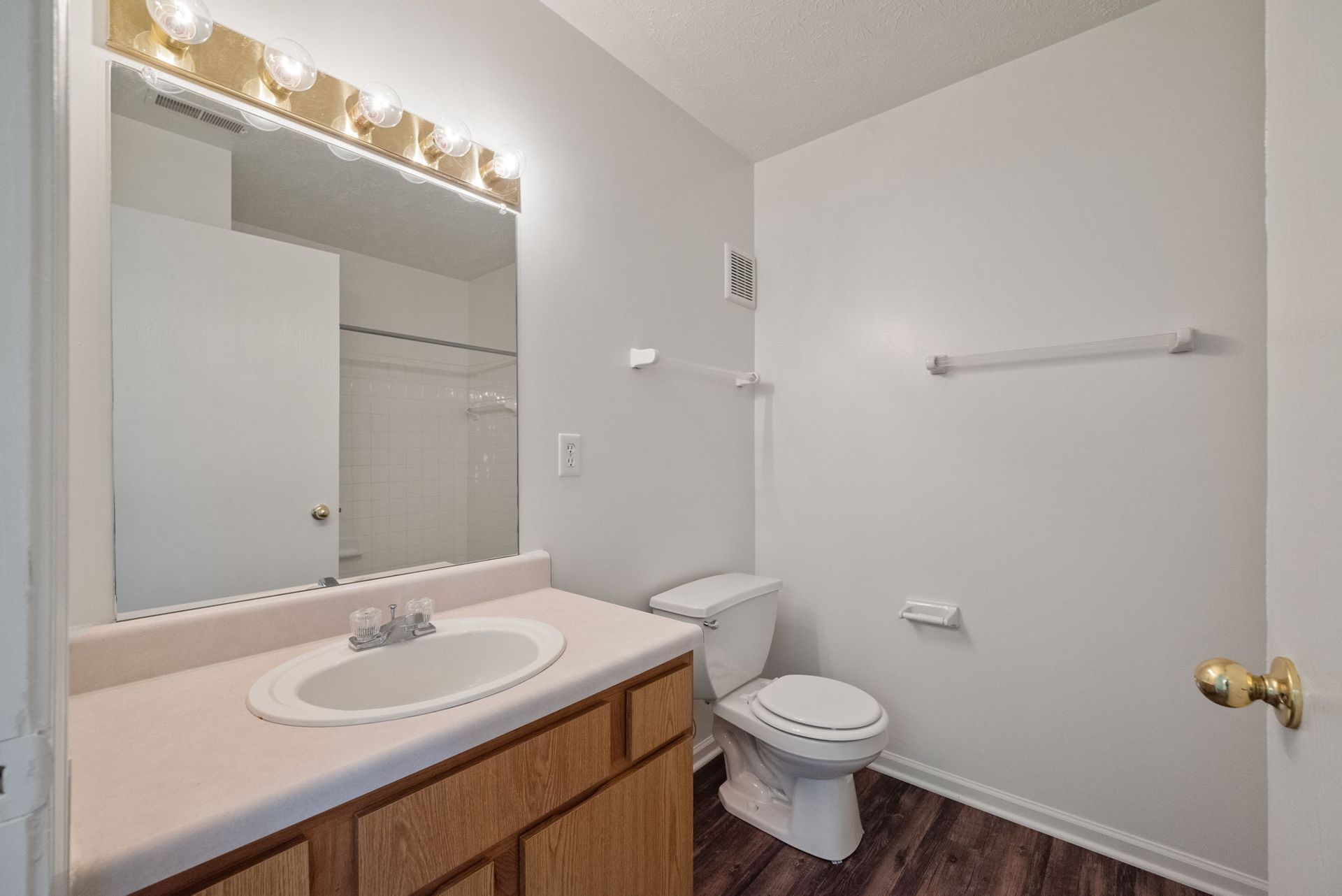 A bathroom with a sink , toilet and mirror.