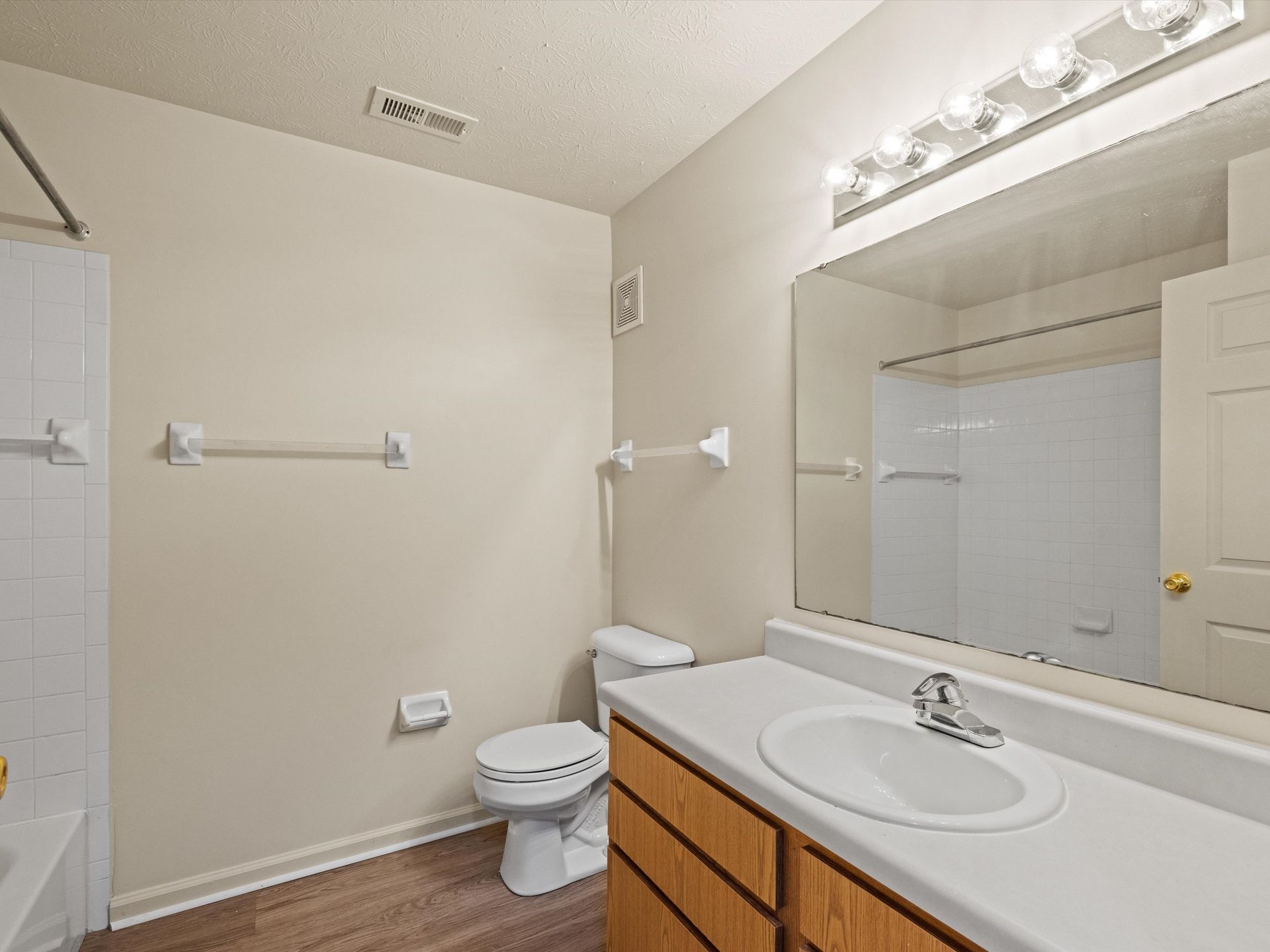 A bathroom with a toilet , sink , and mirror.