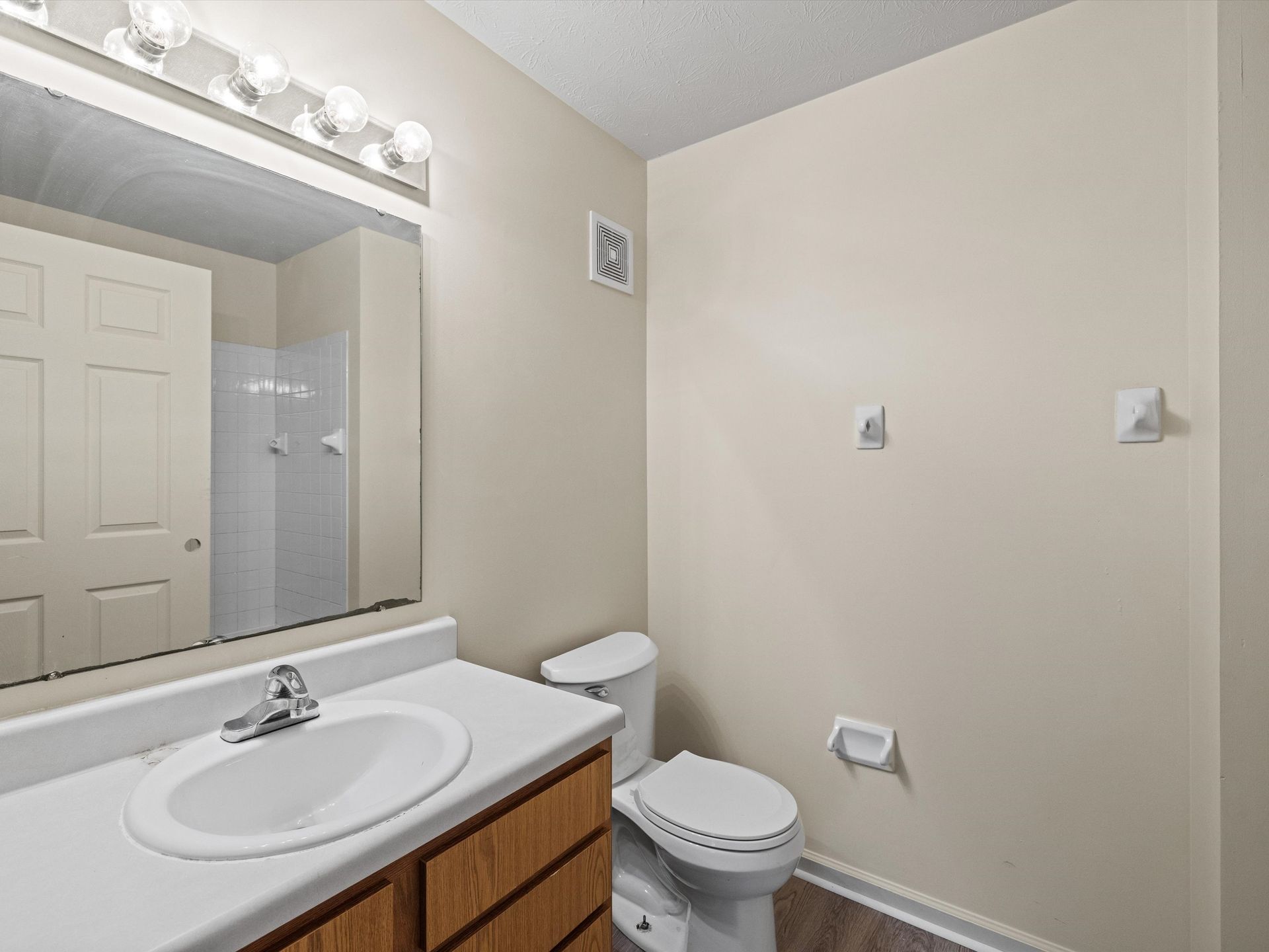 A bathroom with a sink , toilet and mirror.