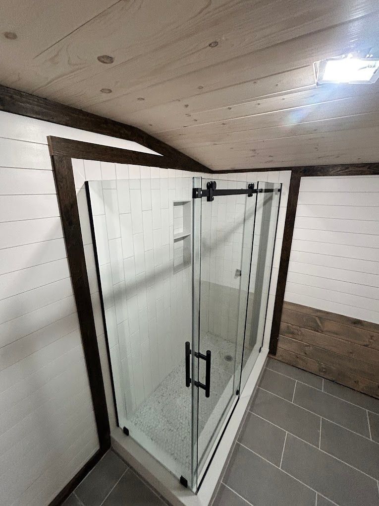 A bathroom with a sliding glass shower door.
