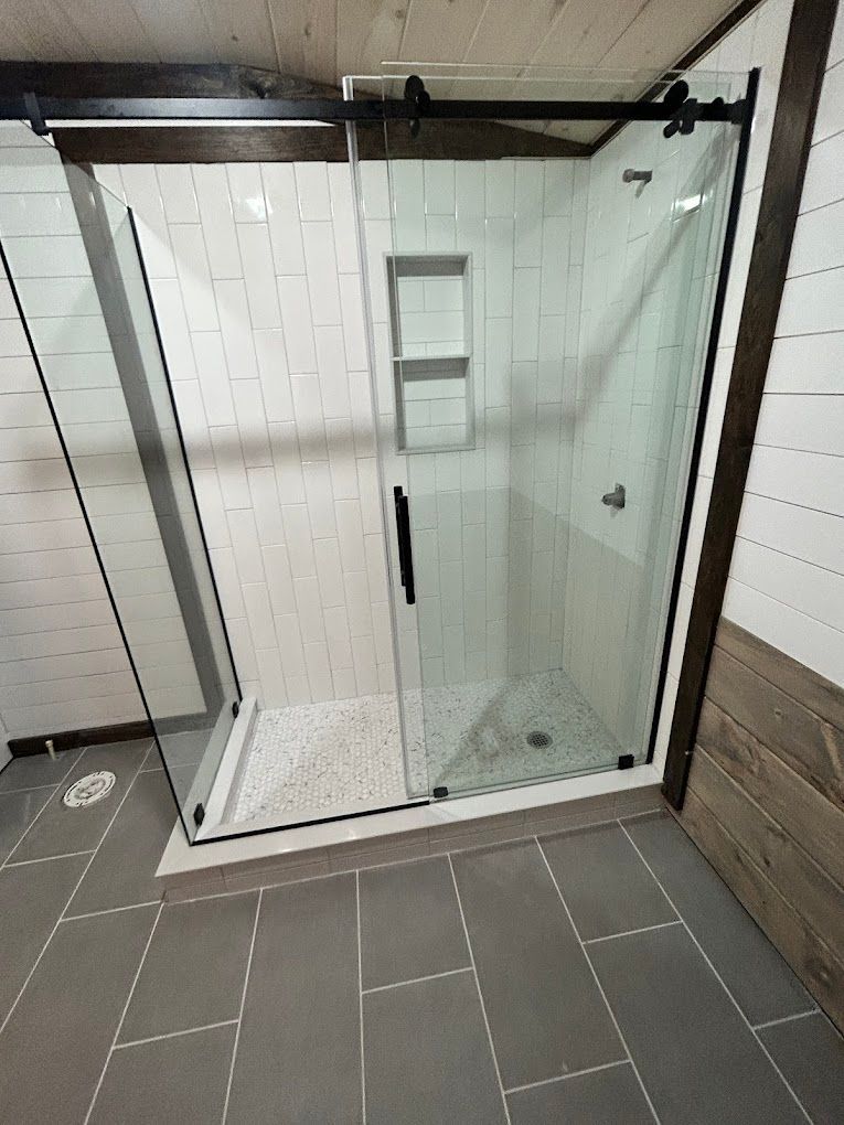 A bathroom with a sliding glass shower door.