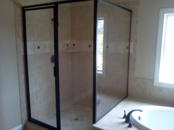A bathroom with a walk in shower and a tub