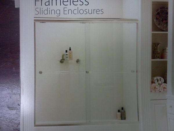 A picture of a frameless sliding enclosure in a bathroom