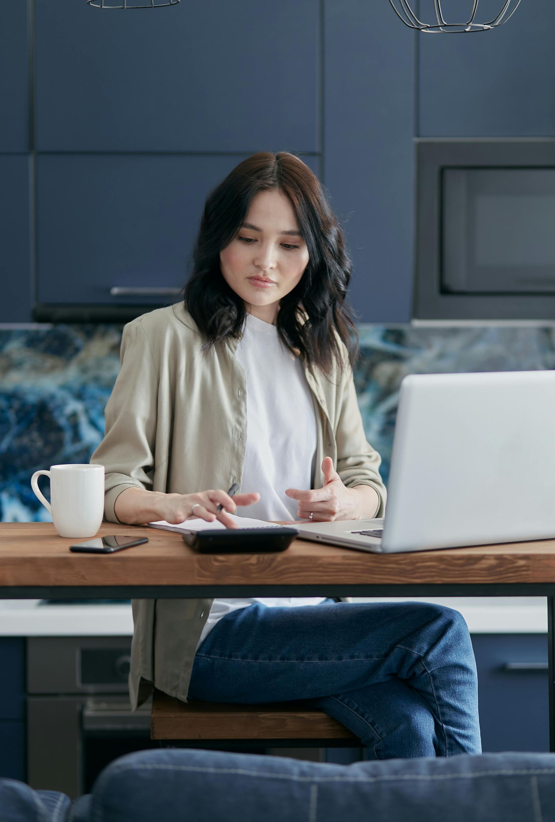 Person analyzing financial charts and graphs on a desk with tablet, papers, and pen