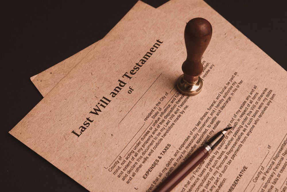 Last Will and Testament document with a pen and a wax seal stamp.