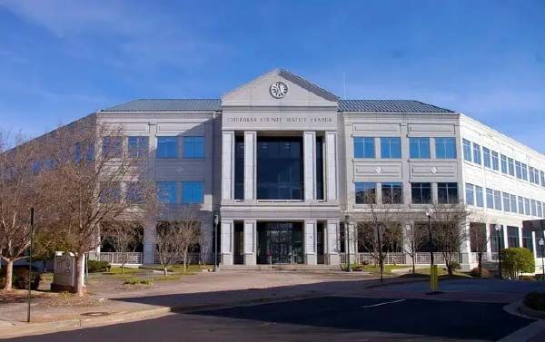 United States Court Center, three-story building with columns, light blue windows, and a clear blue sky.