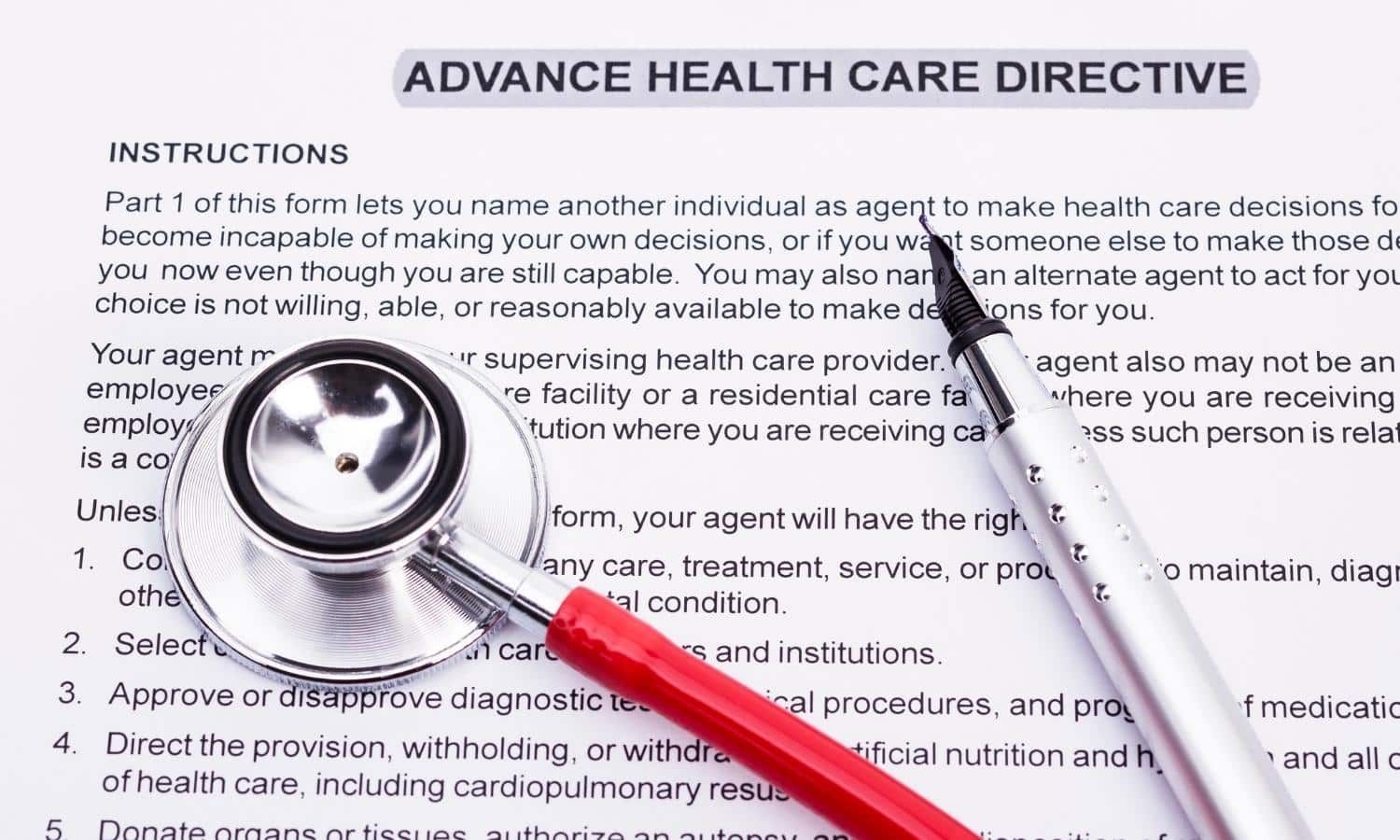 A stethoscope and pen rest on a partially visible Advance Health Care Directive form.