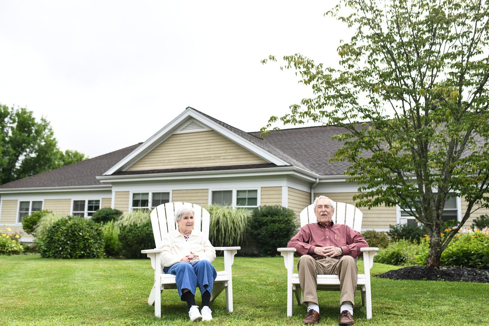 Two residents relaxing outside Bellamy Assisted Living building