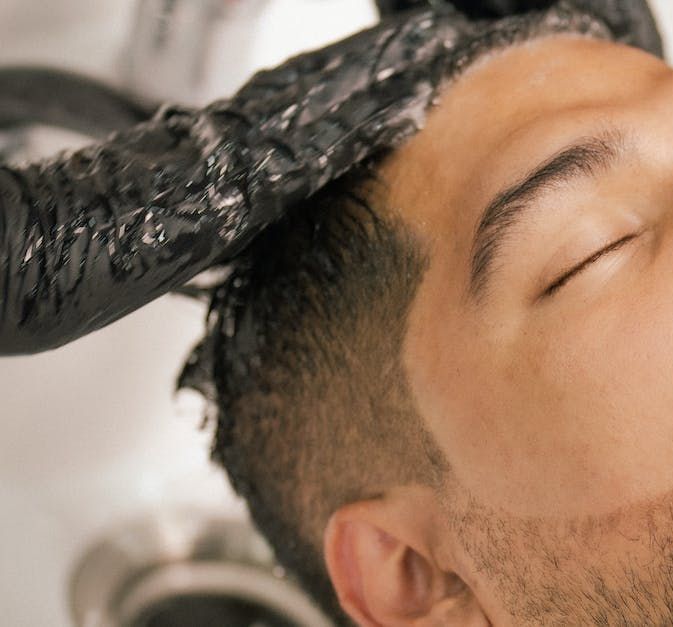 A man is getting his hair washed at a salon.