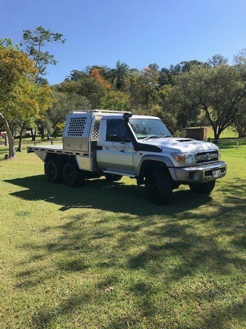 A White Truck Is Parked In A Grassy Field With Trees In The Background — Browns Autobahn In Nambour, QLD