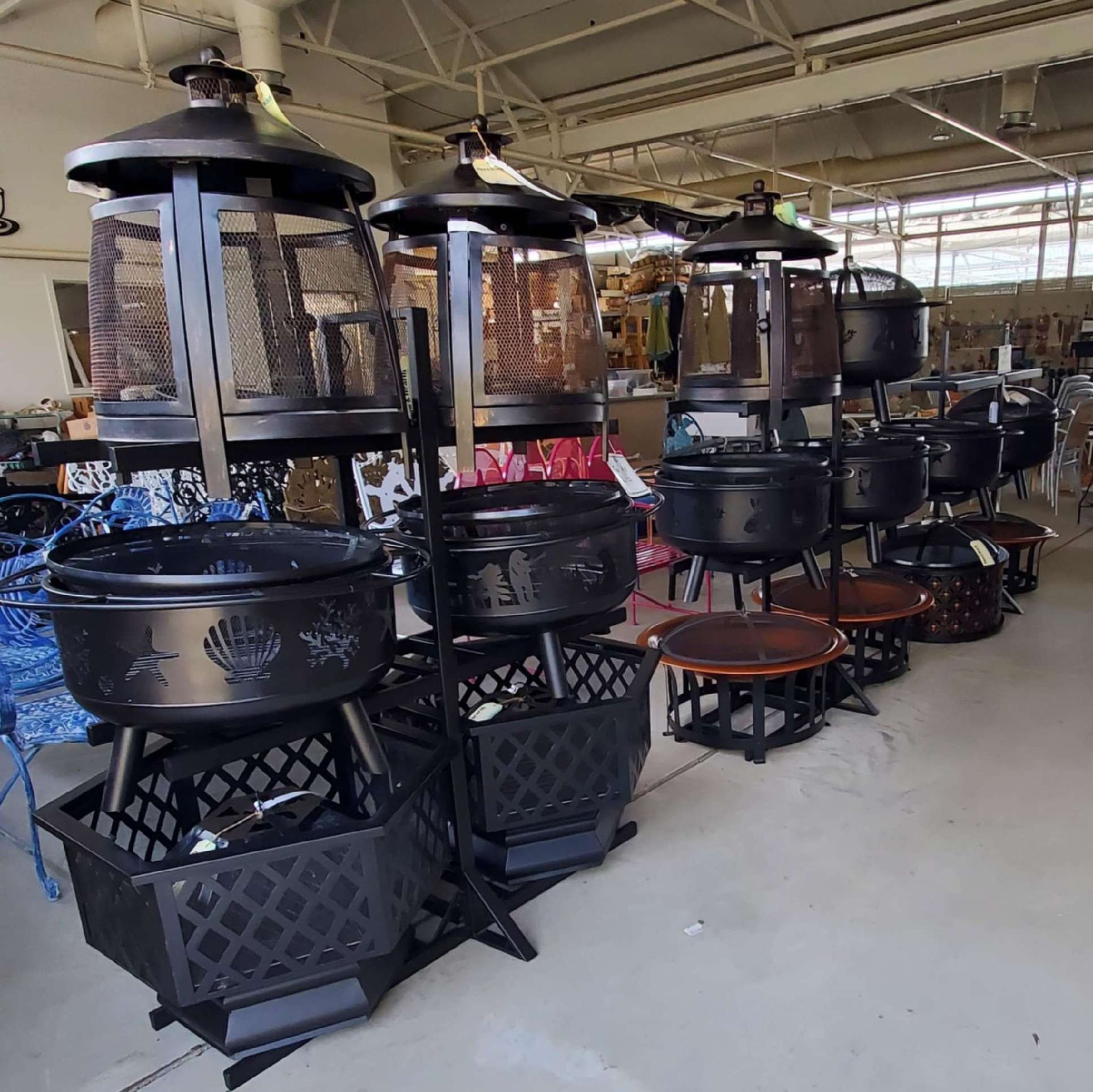 A row of fire pits are lined up in a warehouse