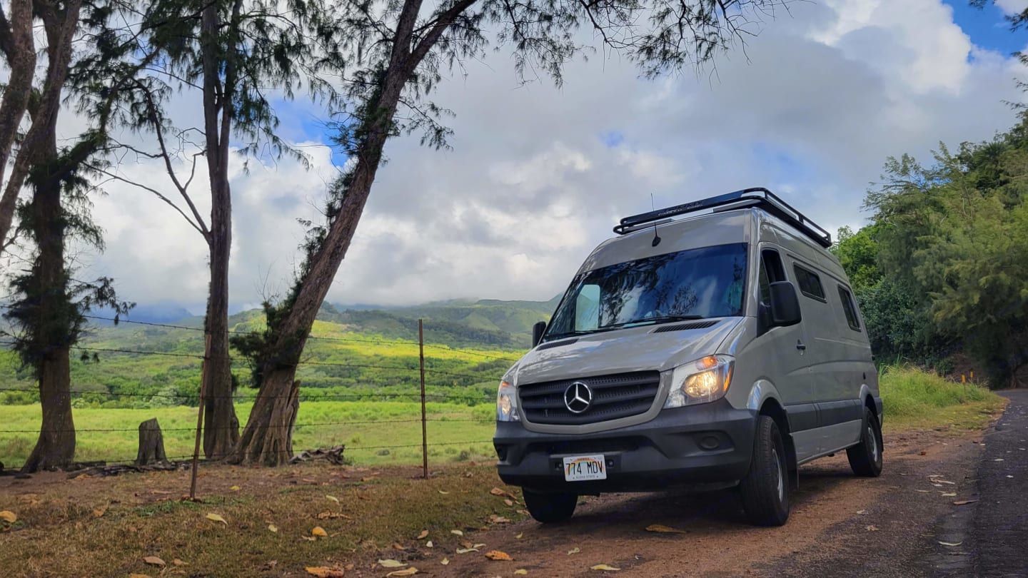 A Mercedes camper van from Mana Vans Hawaii parked roadside near Ke‘anae Uka, surrounded by lush gre
