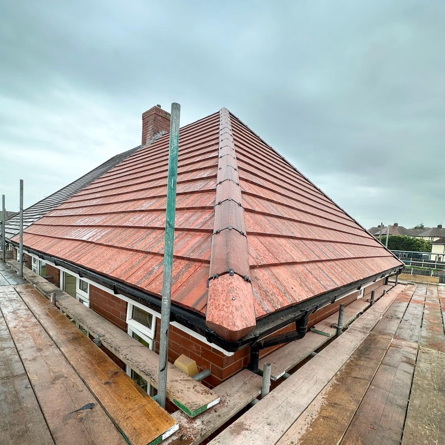 a picture of a hipped roof replacement in red clay tile by Hightop roofers Rotherham