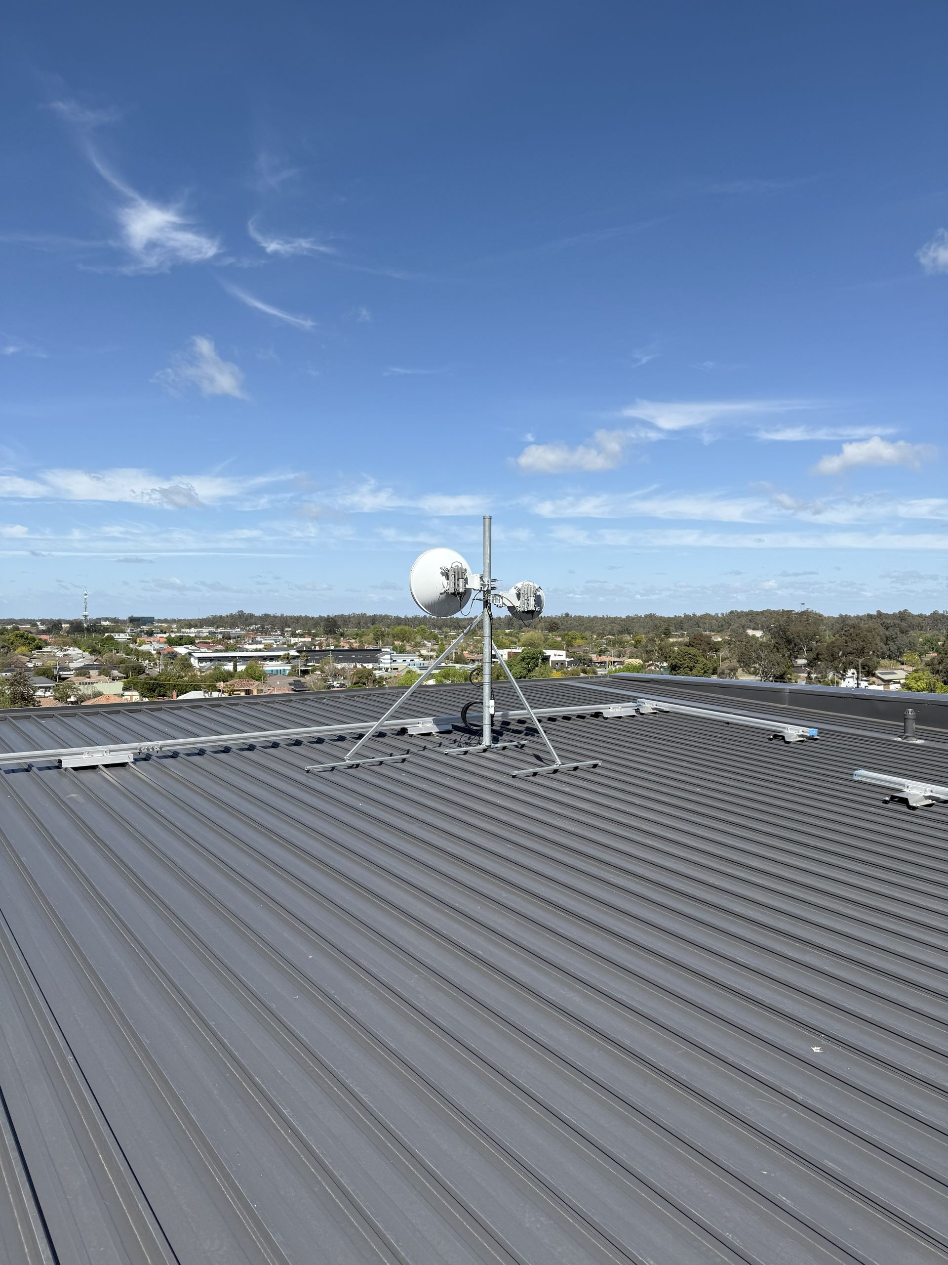 Metal rooftop with communication tower against a blue sky — INtelephony In Albury, NSW