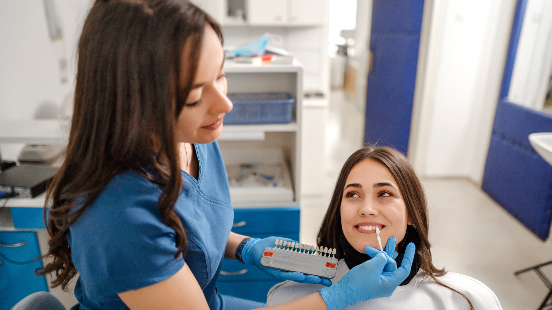 A female dentist is examining a woman 's teeth in a dental office.