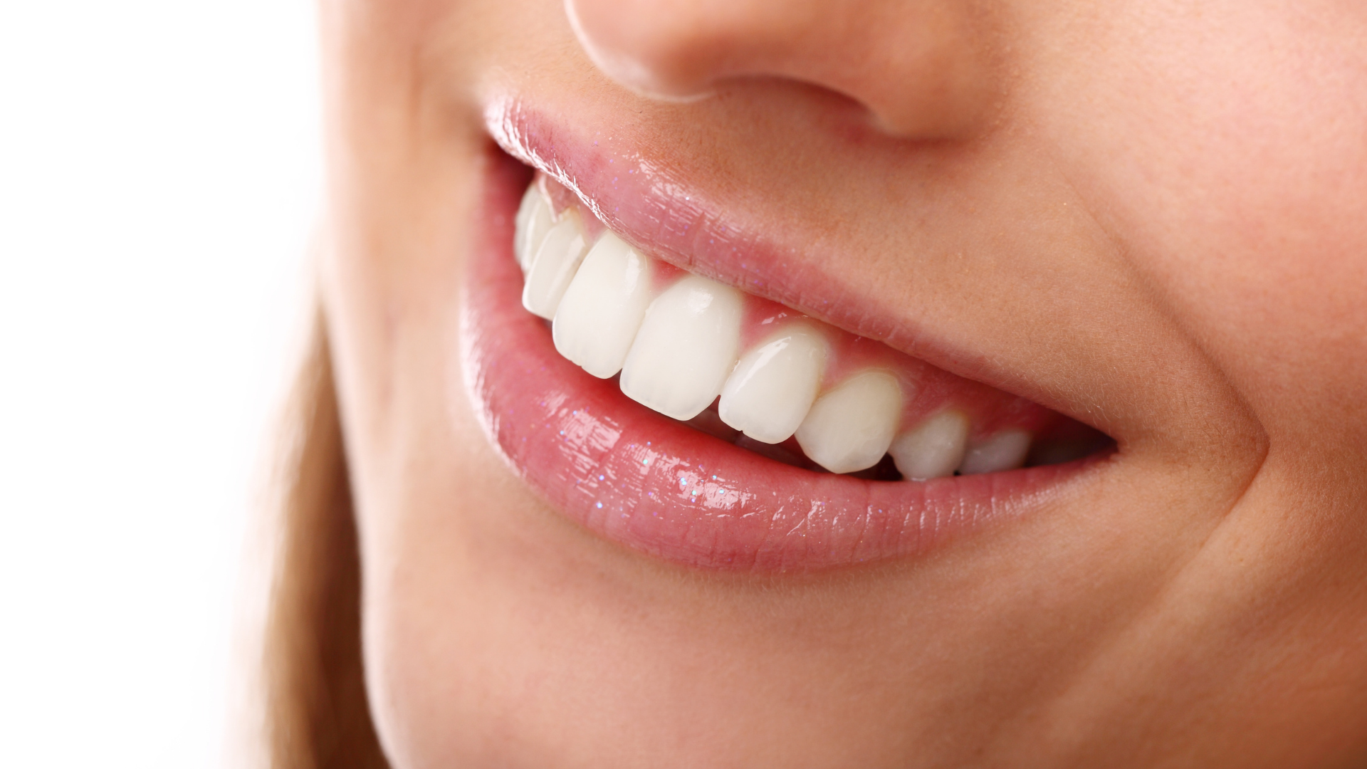 A woman is holding a clear brace in her mouth.
