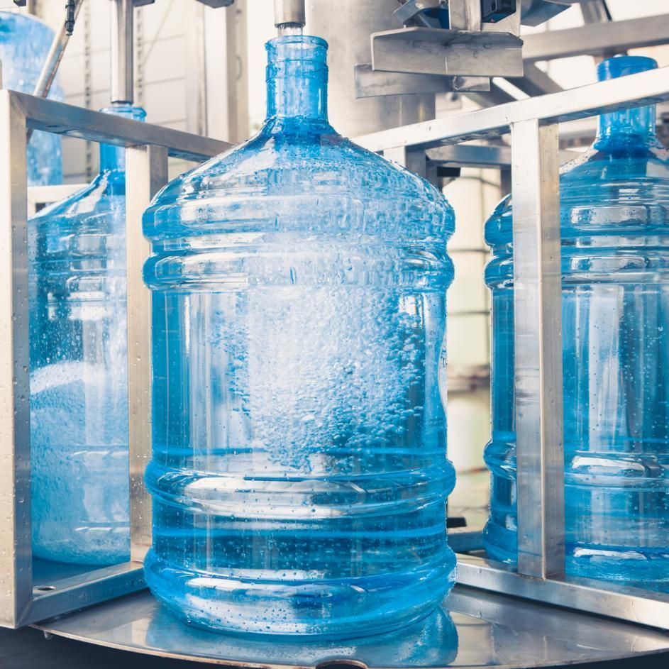 Large Blue Plastic Water Jugs Being Filled on an Industrial Bottling Line — Cool Blue Ice & Water in Tamworth, NSW