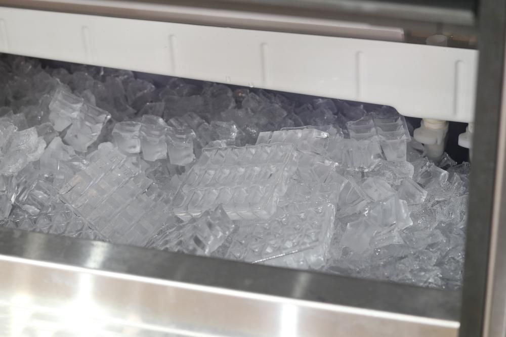 A Bin Full of Clear, Square Ice Cubes Inside a Commercial Ice Machine — Cool Blue Ice & Water in Murrurundi, NSW