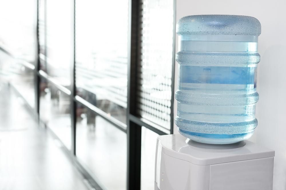 A Large, Clear Plastic Water Jug Sits Atop a White Water Cooler — Cool Blue Ice & Water in Singleton, NSW