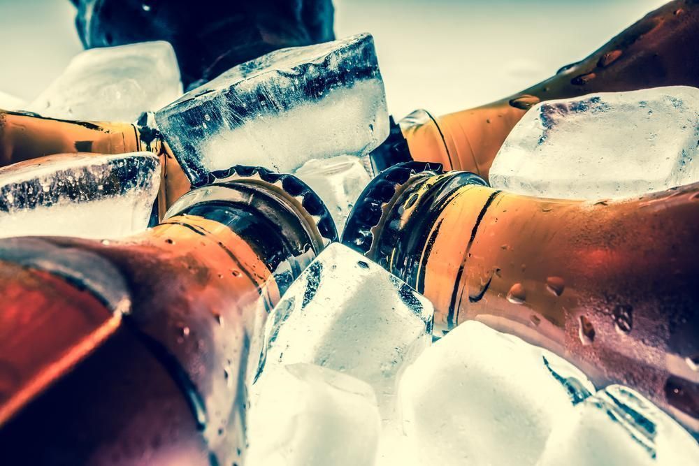 Close-up of Several Glass Beer Bottles Clustered Together — Cool Blue Ice & Water in Taminda, NSW