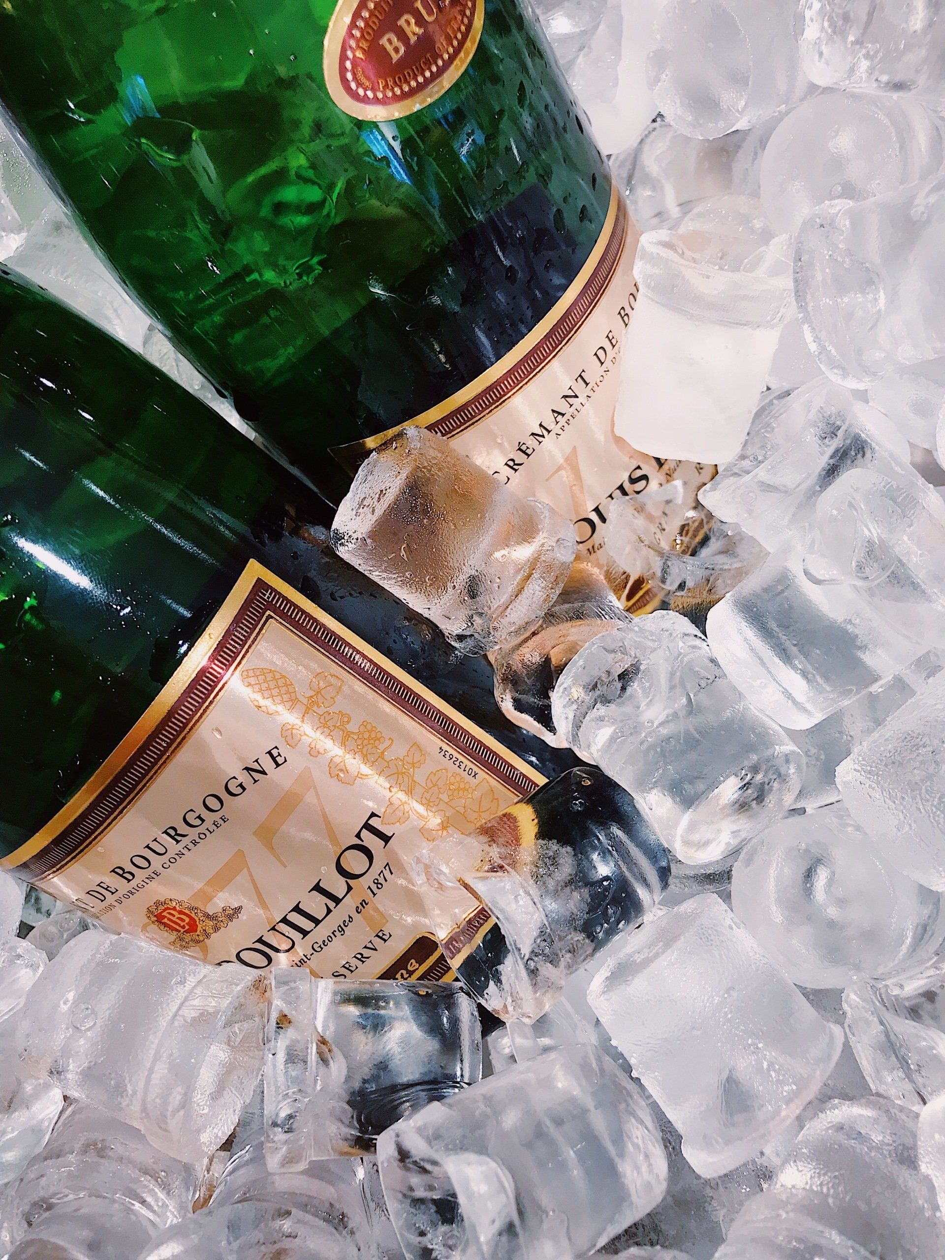 Two Bottles of Guillot Sparkling Wine Nestled in a Bucket of Clear — Cool Blue Ice & Water in Taminda, NSW