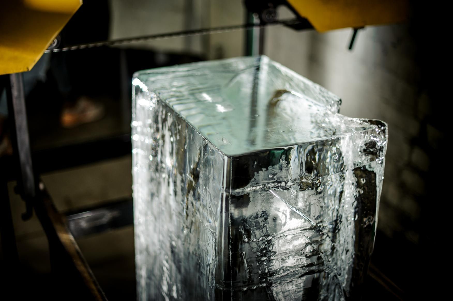 A Large, Clear Block of Ice Sits Under a Mechanical Saw Blade — Cool Blue Ice & Water in Narrabri, NSW