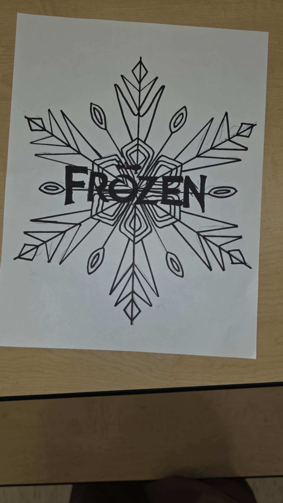 Black and white drawing of a snowflake with the word
