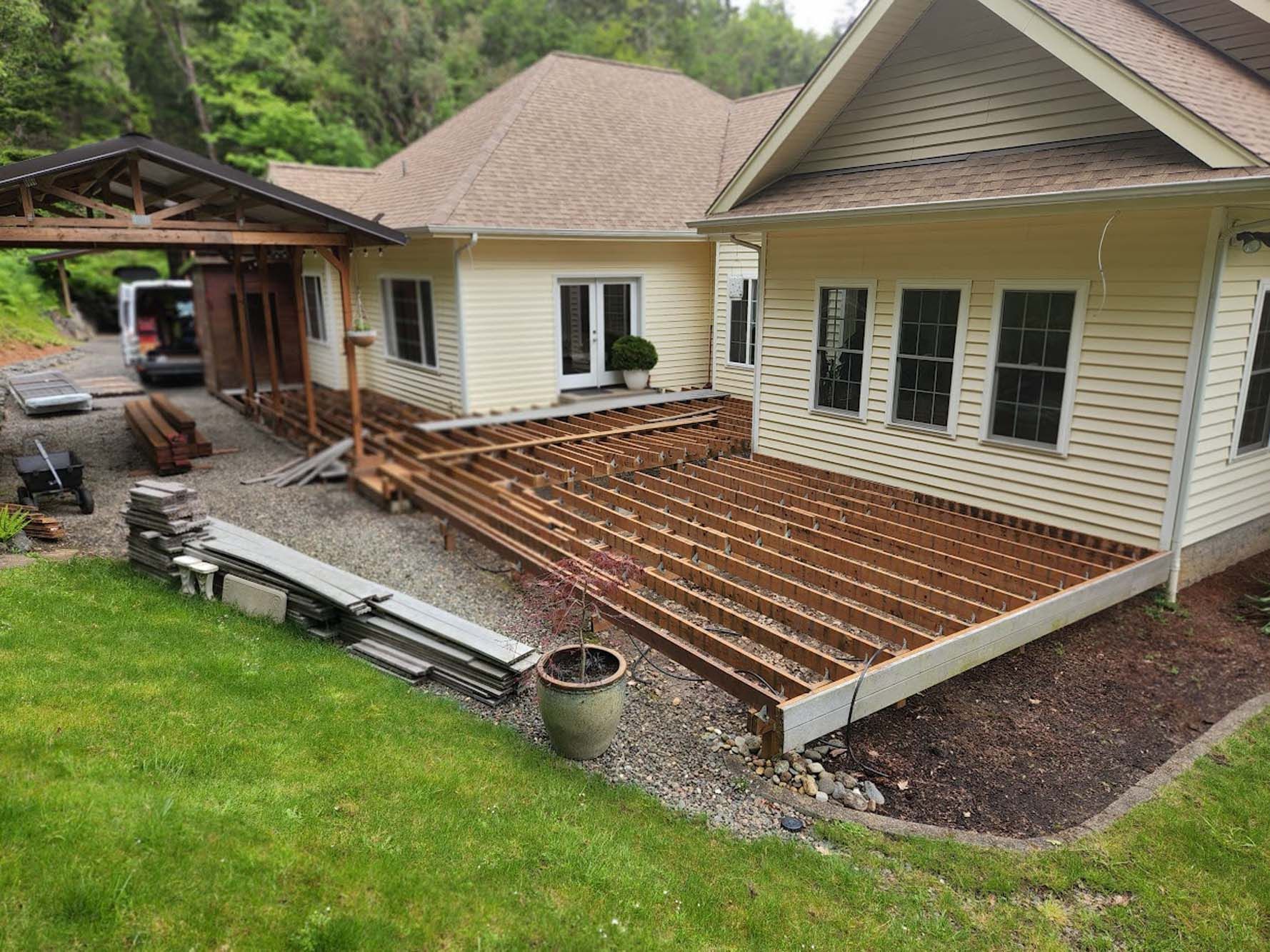 A house with a wooden deck being built on the side of it.
