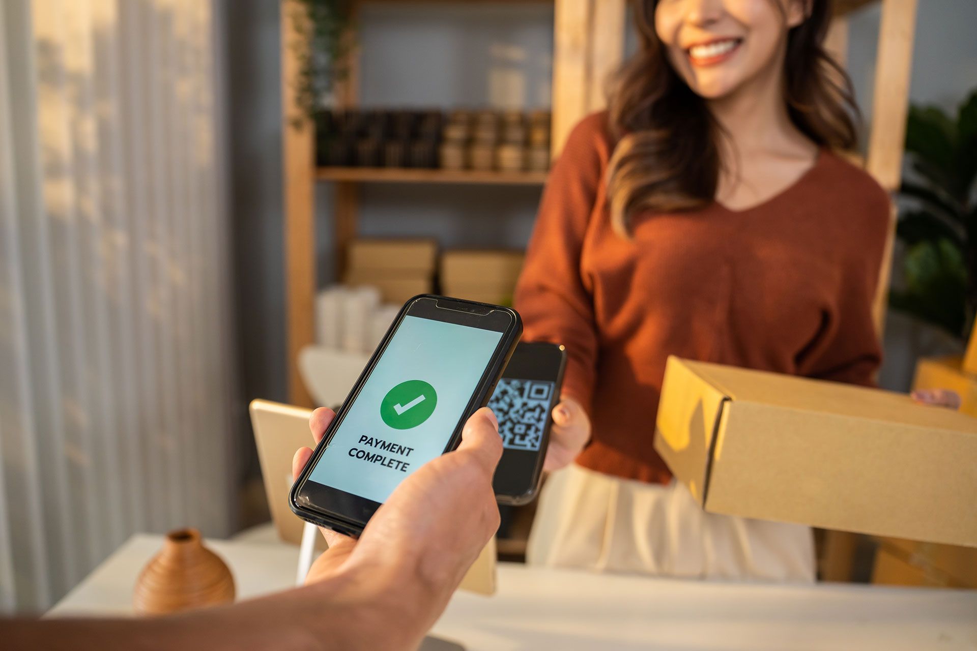 A person is holding a cell phone in front of a woman.