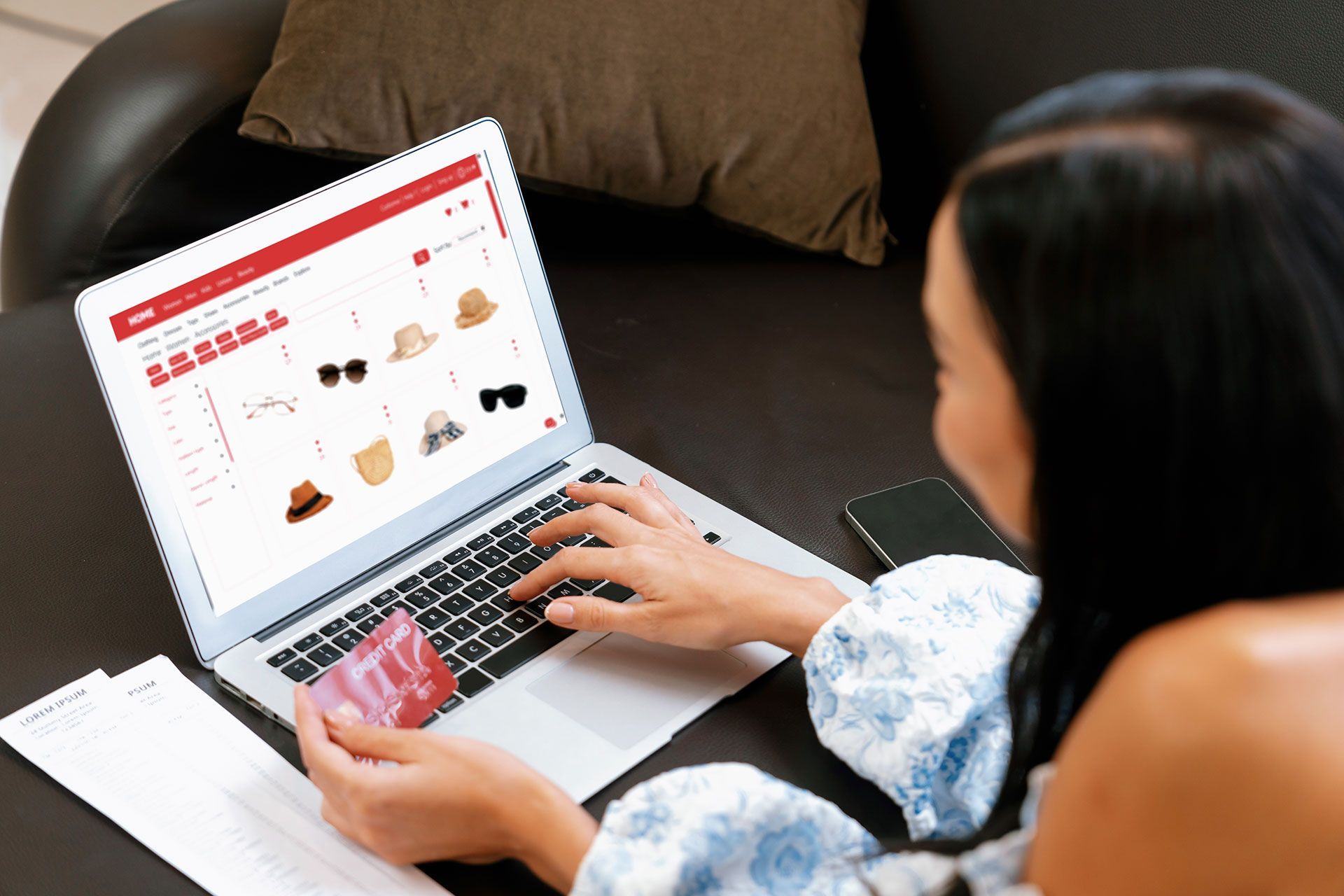 A woman is using a laptop computer while holding a credit card.
