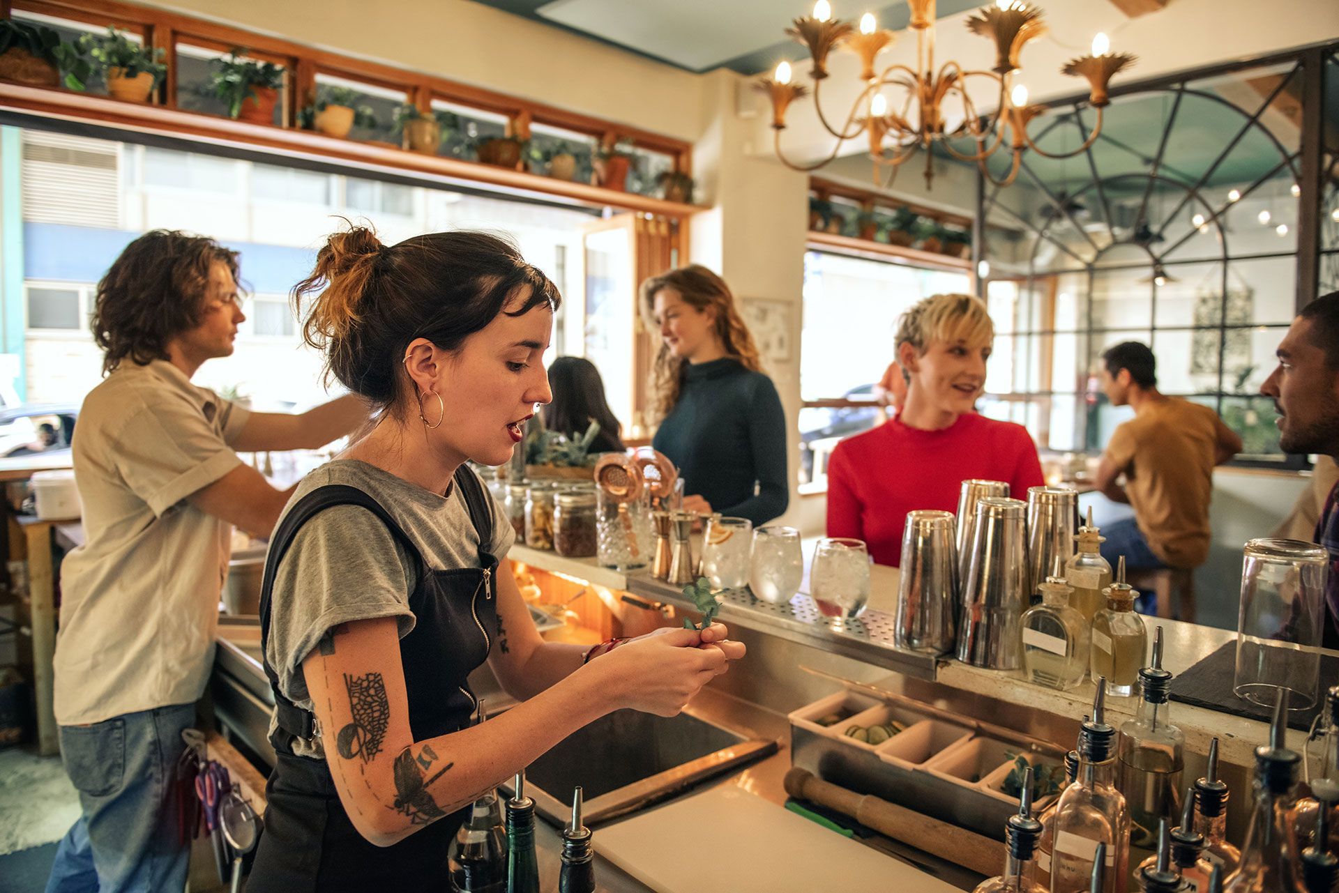 A group of people are standing around a bar in a restaurant.