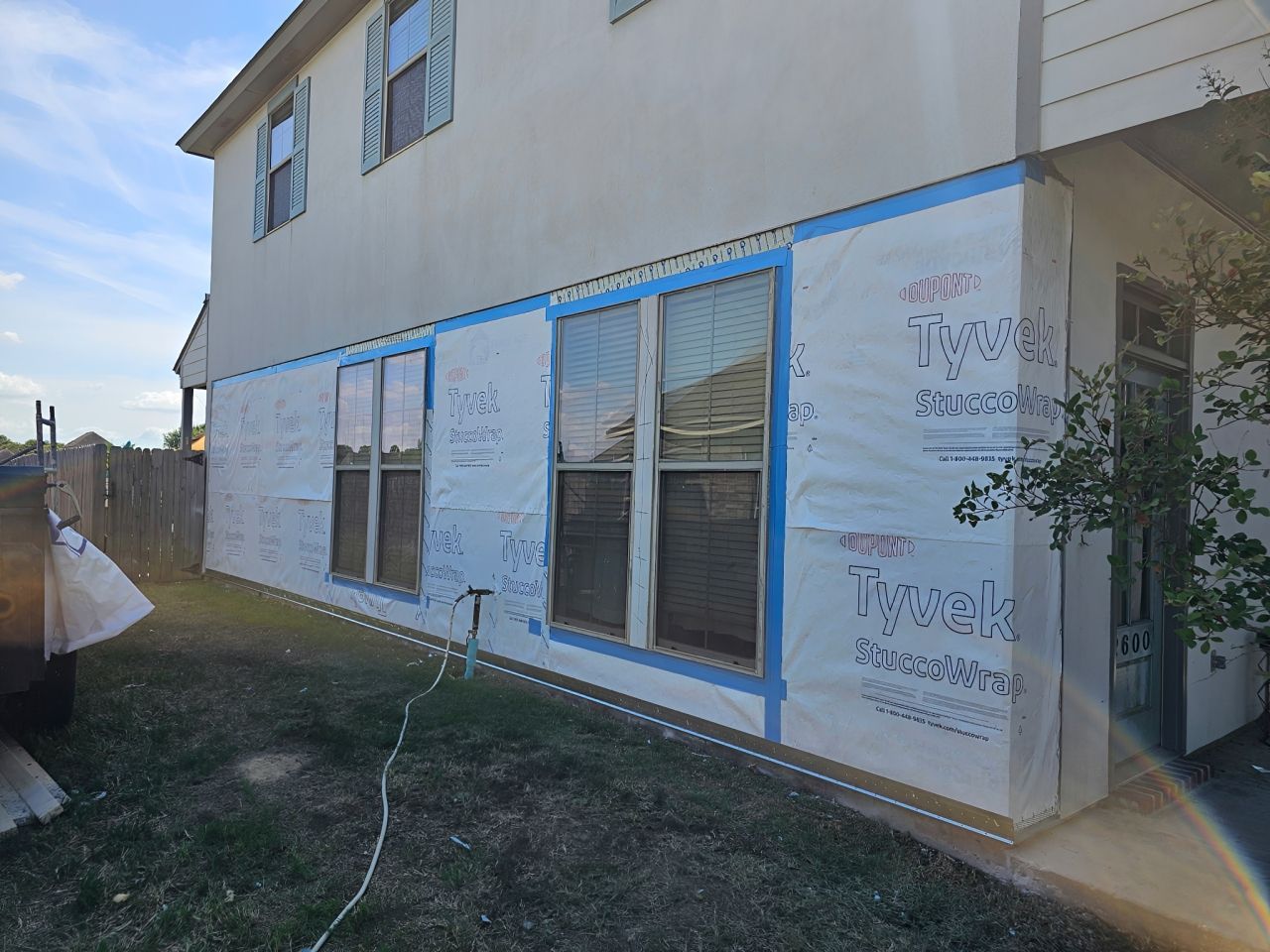 Residential home exterior with stucco wrap preparation before professional stucco installation process.