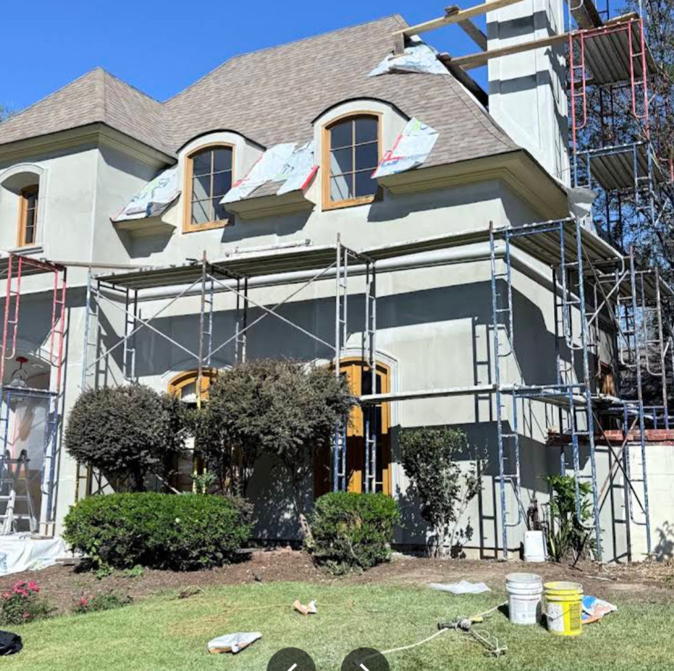 House exterior with scaffolding during renovation on a sunny day