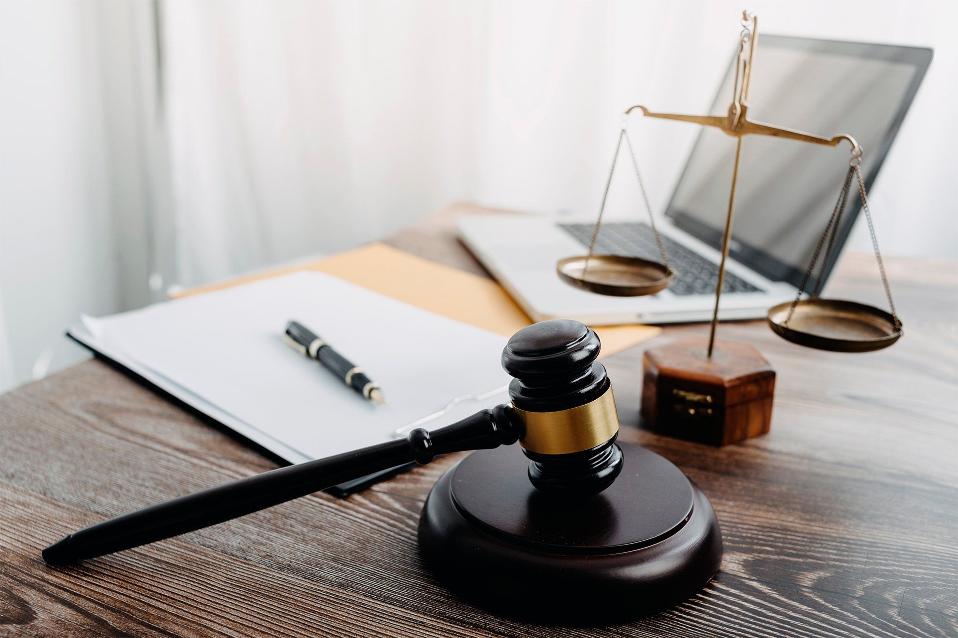 Gavel, Brass Scale, Laptop and Contract Papers on Desk