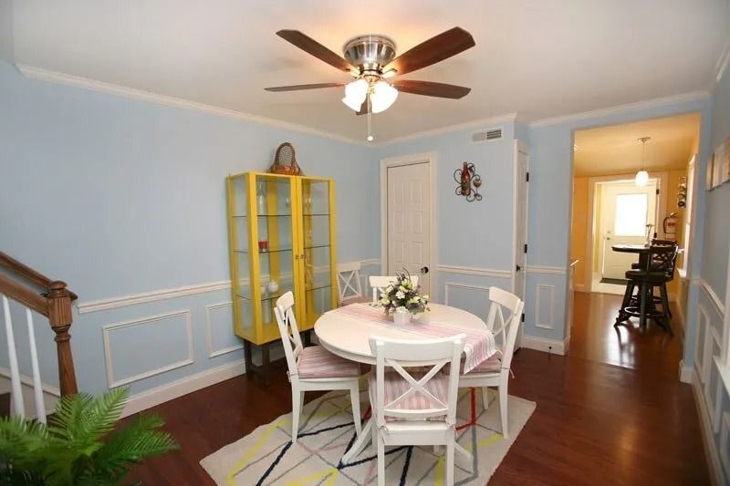 A dining room with a table and chairs and a ceiling fan
