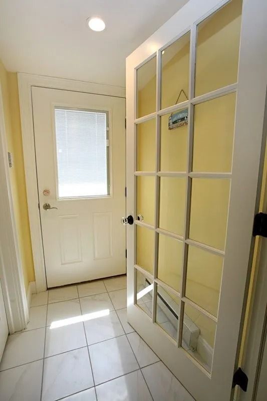 A hallway with a white door and yellow walls
