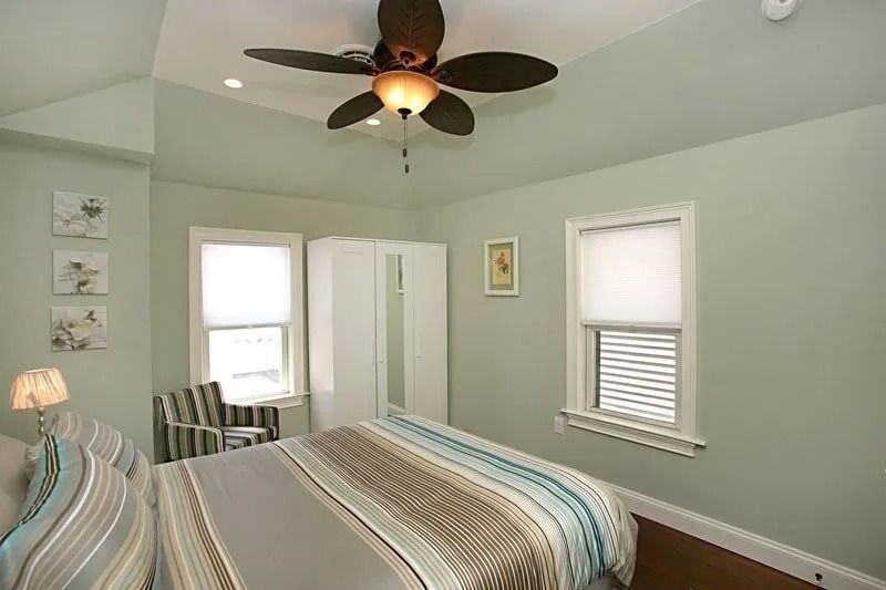A bedroom with a bed and a ceiling fan.
