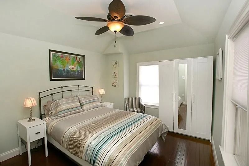 A bedroom with a bed and a ceiling fan