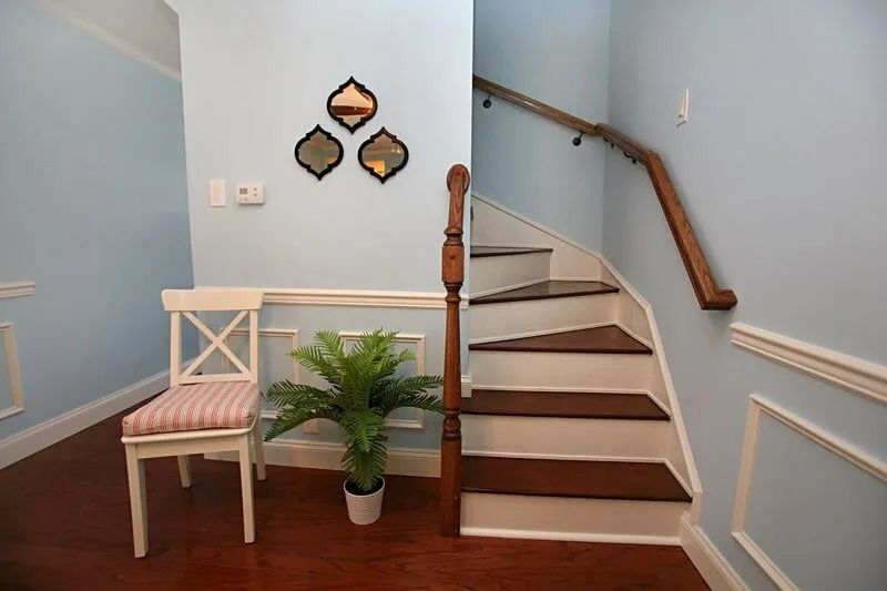 A staircase in a house with a chair and a plant
