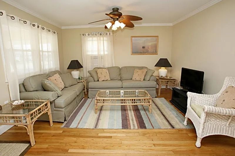 A living room with two couches and a ceiling fan