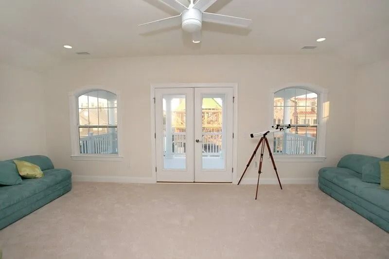 A living room with a telescope and a ceiling fan