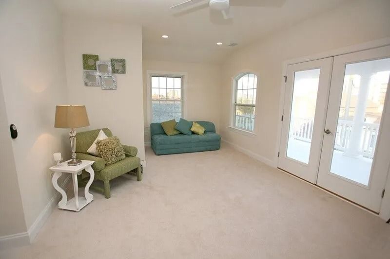 A living room with a couch , chair , lamp and sliding glass doors.