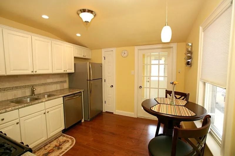 A kitchen with a table and chairs and a refrigerator