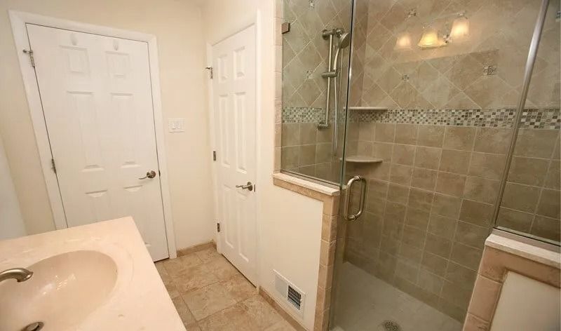 A bathroom with a walk in shower and a sink.