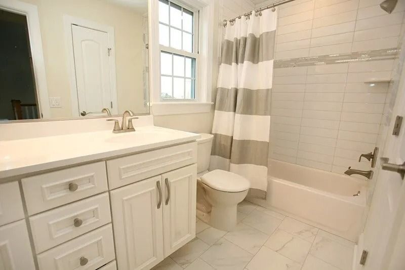 A bathroom with a sink , toilet , shower and bathtub.